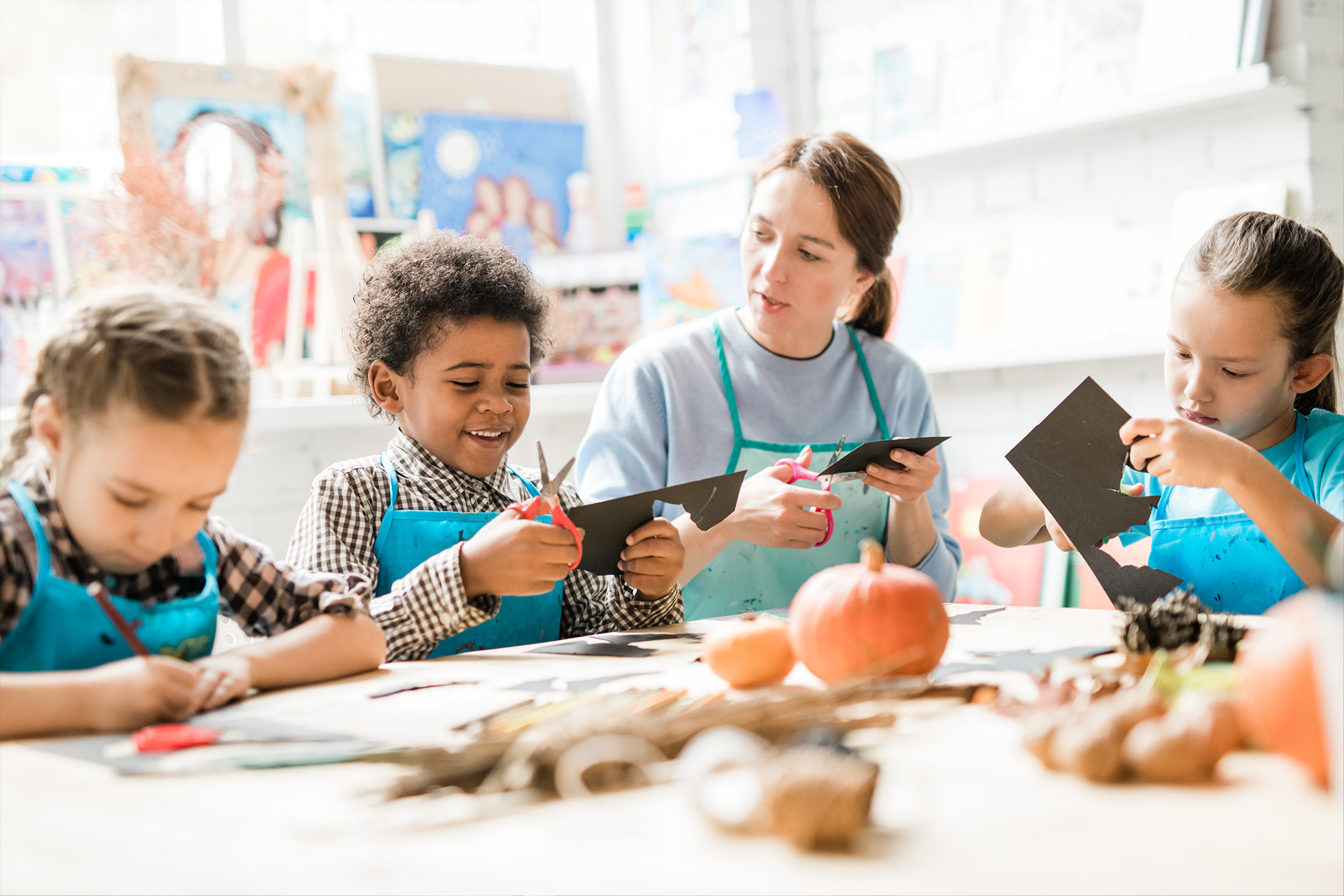 Kinder und Lehrerin beim herbstlichen Basteln